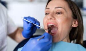 Dentist examining patient's teeth during gum disease evaluation in Houston.
