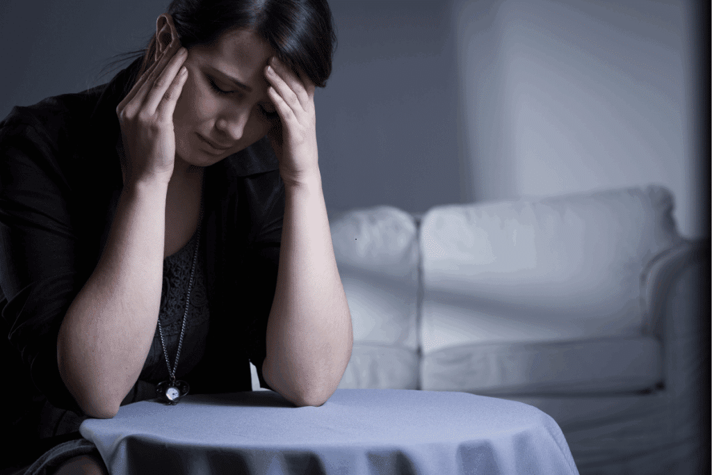 Woman experiencing dental pain or stress, holding her head with both hands.